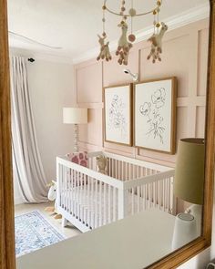 a baby's room with pink walls and white crib in the foreground