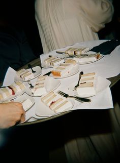 a table topped with lots of desserts and plates filled with cake sitting on top of each other