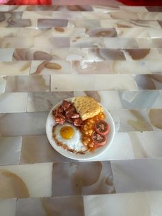 a breakfast plate with eggs, toast and sausage on it sitting on a checkered table cloth