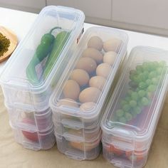 three plastic containers filled with food on top of a wooden table next to a cutting board