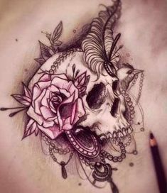 a woman's stomach with a skull and rose tattoo on it