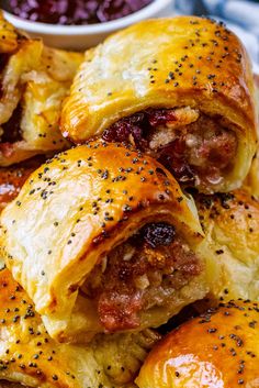 sausage and cheese pastries on a plate with a bowl of sauce in the background