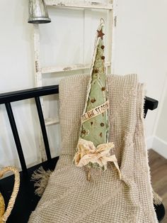 a chair with a pillow on top of it and a christmas tree decoration hanging from the back