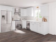 a kitchen with white cabinets and stainless steel appliances, along with wood flooring that matches the walls