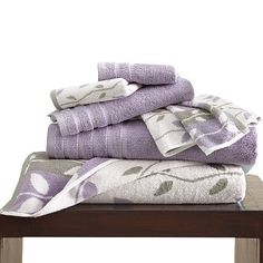 a stack of towels sitting on top of a wooden table