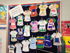 a bulletin board with t - shirts hanging from it's sides in a classroom