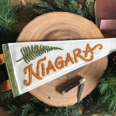 there is a sign that says niagara on the side of a piece of wood next to a pair of scissors