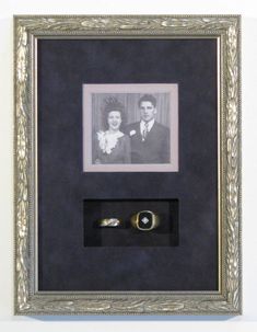 an old photo is hanging on the wall with a ring in it's holder