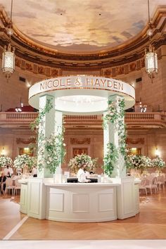 the inside of a building decorated with flowers and greenery