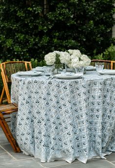 the table is set for two with white flowers in vases