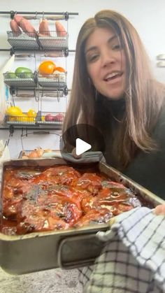 a woman holding a pan filled with food