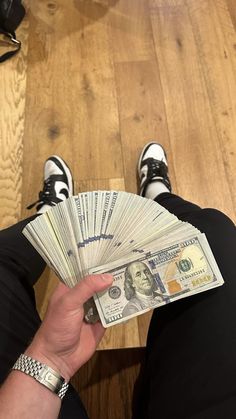 a person sitting on the floor holding money