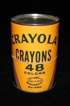 a can of crayons sits on a black surface