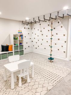 a room with white furniture and shelving on the wall, including a small table