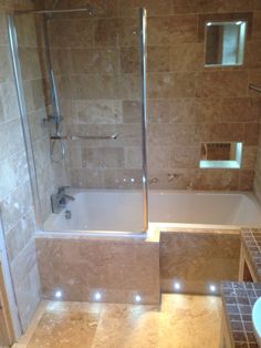 a bathroom with a walk in shower next to a bath tub