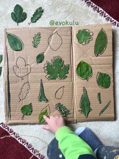 a child is playing with leaves on the floor