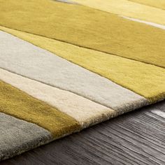 a yellow and gray rug on top of a wooden floor