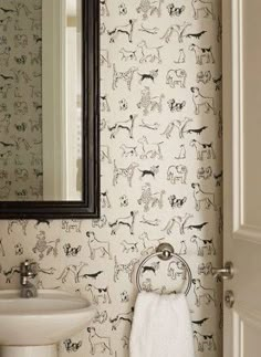 a white sink sitting under a bathroom mirror next to a wall mounted faucet