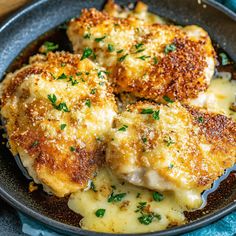 three pieces of chicken with cheese and parsley in a skillet