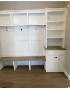 an empty room with some white cabinets and shelves on the wall next to each other