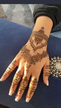 a woman's hand with henna tattoos on it