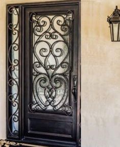 an ornate iron door on the side of a house