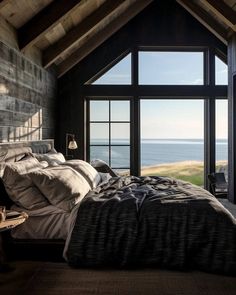 a bedroom with a large window overlooking the ocean