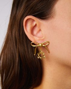 A Mensch is a very elegant person and my oh my if these earrings aren't the most elegant! Our lovely hand crafted bronze bow with a twinkling jewish star below. How Menschy! Sold as a pair. Drop: 1" All jewelry is made by hand to order. Jewelry will ship 2-3 weeks from the order date (if not sooner!) Elegant Sterling Silver Hoop Earrings With Dangling Charms, Brass Drop Earrings, Clip-on, Brass Drop Earrings With Clip-on, Clip-on Brass Drop Earrings, Elegant Single Earring As Gift, Formal Single Pendant Earring, Formal Brass Bridal Earrings, Classic Gold-plated Linear Earrings As Gift, Classic Gold Plated Linear Earrings As Gift