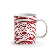 a red and white coffee mug with an image of a crown on it's side