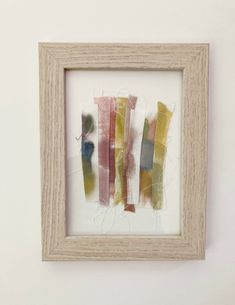 an art work with different colors in a wooden frame