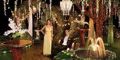 a man and woman posing for a photo in front of a fountain with lights on it