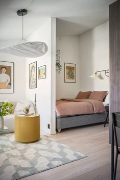 a bedroom with white walls and wood floors