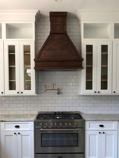 a stove top oven sitting inside of a kitchen next to white cupboards and cabinets