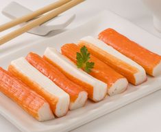 several pieces of food on a plate with chopsticks