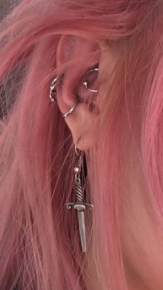 a woman with pink hair and piercings on her ear