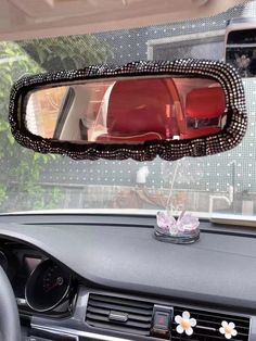 a car's rear view mirror is decorated with black and white beads