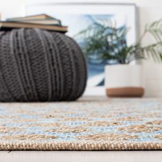 a ball of yarn sitting on top of a rug next to a potted plant