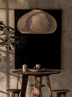 a wooden table with four stools under a hanging light fixture in a dining room