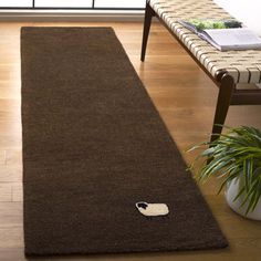 a brown rug with a black and white cat on it in front of a window