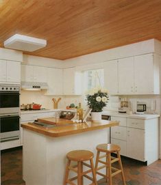 a modern kitchen with white cabinets and wood flooring is pictured in this image - stock image