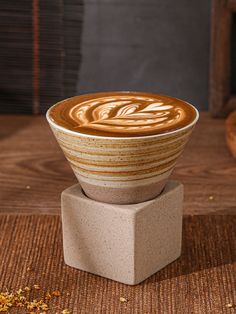 a cup of coffee sitting on top of a wooden table