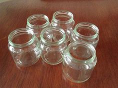 six glass jars sitting on top of a wooden table