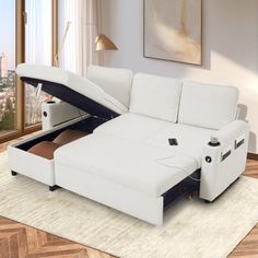 a white leather sectional sofa with pull out bed and storage compartment on the bottom shelf