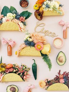 an arrangement of flowers and sushi arranged on a white surface with the word sushi spelled out in cursive writing