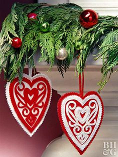 two crocheted hearts hanging from a christmas tree