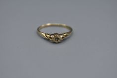 an old gold ring with a stone in the middle and a small diamond on top