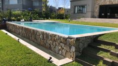 an empty swimming pool with steps leading up to it and grass in the foreground