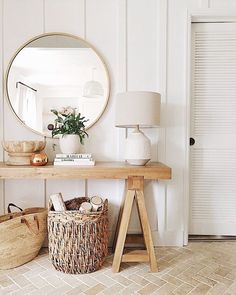 a wooden table topped with a round mirror