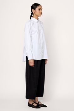 Introducing our timeless Museo Button-Up, inspired by classic menswear designs. Crafted from premium organic cotton poplin with a soft washer finish, this shirt embodies relaxed elegance. Its loose fit is complemented by curved hems at the front and back, along with a single box pleat at the back yoke for added sophistication. Wear it tucked into our Boyfriend Trouser for a polished look, or pair it effortlessly with our Barrel Leg Denim for a relaxed ensemble. Made with 100% Organic CottonHandm Boyfriend Trousers, Relaxed Elegance, Classic Menswear, Indian Textiles, Box Pleats, Tunic Length, Mother Of Pearl Buttons, Polished Look, Classic Shirt