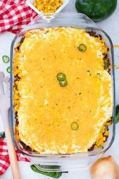 an enchilada casserole in a glass dish with green peppers and corn